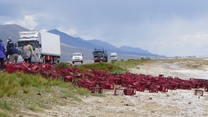 ビール運搬車の事故で、道路わきにまでケースが散乱。