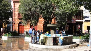 噴水から水をくむ子どもたち。